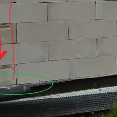 Widoczne trzpienie żelbetowe w ścianach murowanych z bloczków betonowych, wzmocnienie narożnika.