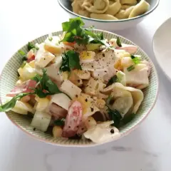Pyszna sałatka z tortellini, jajka, kukurydzy i pomidorów, polana kremowym sosem. Idealna na szybki obiad lub kolację.