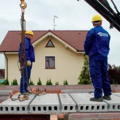 Pracownicy montują prefabrykowane płyty, prezentując różne rodzaje stropów. Budowa domu z wykorzystaniem nowoczesnych technologii.
