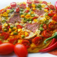 Pyszna pizza pepperoni z pomidorkami, papryką i zielonym groszkiem, otoczona świeżymi papryczkami chili i pomidorami.