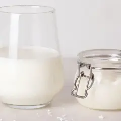 Un verre de lait et un pot de lait de beurre, prêts pour une recette gourmande.