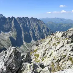 Kamienista grań na trasie na Koprowy Wierch. Majestatyczne szczyty Tatr Wysokich w tle.