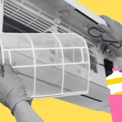 Manos con guantes sacan el filtro del aire acondicionado para limpiarlo.