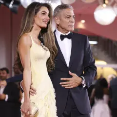 Elegancka para na czerwonym dywanie. Ona w żółtej sukni, on w garniturze. Idealny przykład damskiego black tie dress code.