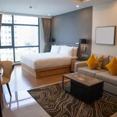 Nowoczesny pokój hotelowy z łóżkiem, sofą i biurkiem. Szukasz alternatyw, gdzie szukać noclegów oprócz Booking?