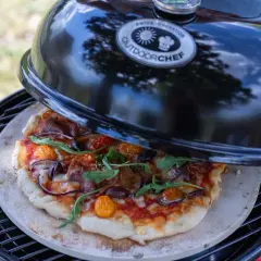 Selbstgemachte Pizza auf einem Pizzastein im Outdoorchef Grill. Die Frage ist nur, wieviel Grad im Ofen für den perfekten Biss?