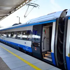 Pociąg PKP Intercity na peronie, tablica informacyjna pokazuje odjazd do Krakowa. Czekam na pociąg, mam nadzieję, że nie będzie awarii PKP.