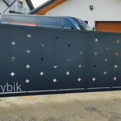 Nowoczesna brama przesuwna z ażurowym wzorem w kształcie rombów, idealna do posesji o standardowych wymiarach.