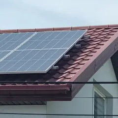 Panele fotowoltaiczne na dachu domu, zbierające energię słoneczną.