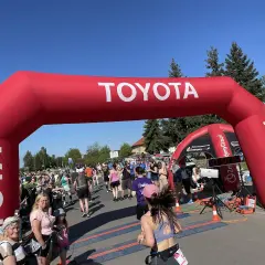 Uczestnicy biegną pod czerwonym łukiem Toyoty. Czy to już koniec półmaratonu? Jaki dystans pokonali?