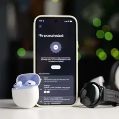 Smartfon z włączonym trybem nie przeszkadzać Samsung, obok słuchawki i smartwatch.