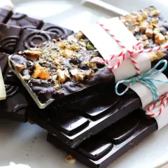 Selbstgemachte Schokolade: Dunkle Tafeln mit Nüssen und eine weiße mit Beeren und Früchten, bereit zum Genießen.