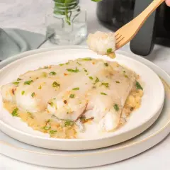 Deliciosa merluza en salsa, recién hecha en airfryer. Un bocado perfecto con perejil fresco.