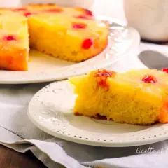 Una fetta di torta ananas, con la sua base dorata e la copertura di frutta caramellata, pronta per essere gustata.