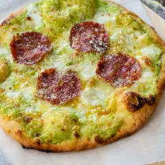 En pizza bianco med salami, ost och grön sås.