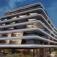 Nowoczesny hotel 5 gwiazdkowy z falującymi tarasami i subtelnym oświetleniem, otoczony zielenią.