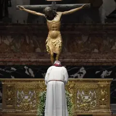 Uroczysta droga krzyżowa w Wielki Piątek. Papież klęczy przed ołtarzem, kontemplując ukrzyżowanego Chrystusa.