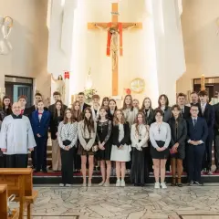 Młodzież w kościele, gotowa do bierzmowania w jakim wieku. Uroczystość z księdzem i rodzinami.
