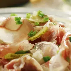 Ein deftiger Ochsenmaulsalat mit Gurken und Zwiebeln, garniert mit Schnittlauch. Perfekt für ein herzhaftes ochsenmaulsalat rezept.