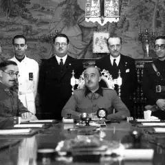 Luis Alarcón de la Lastra, rodeado de militares y civiles, en una reunión formal.