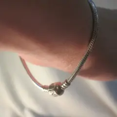 Srebrna bransoletka Pandora na nadgarstku. Dowiedz się, jak dobrać rozmiar bransoletki Pandora, by idealnie pasowała.