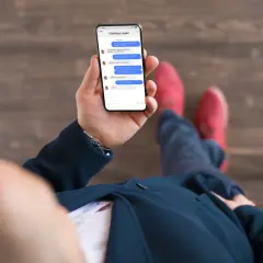 Chcesz wiedzieć, jak sprawdzić z kim pisze Twoja dziewczyna na FB? Ten mężczyzna trzyma telefon, na którym widać rozmowę z Christiną Logan.