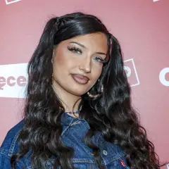 Młoda Viki Gabor, z charakterystycznymi kucykami i w dżinsowej kurtce, pozuje na ściance. Jej wiek to tajemnica, ale talent jest oczywisty.