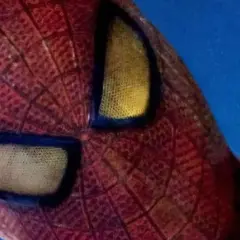 Zbliżenie na charakterystyczne, żółte oczy Spidermana na czerwonym tle.