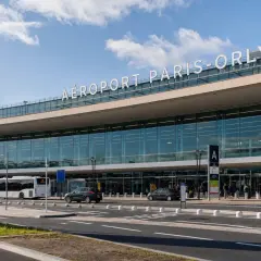 La navette Paris Orly attend devant l'aéroport. Panneaux indicateurs pour les entrées, départs et arrivées.
