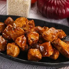 Aksamitny filet z indyka w sosie, podany na czarnym talerzu, kusi apetycznym wyglądem.