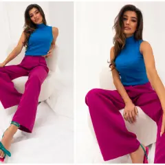 Modelka w stylizacji, która udowadnia, czy niebieski pasuje do różowego. Wyraziste kolory i luźne spodnie tworzą modny look.