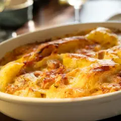 Un délicieux gratin dauphinois aux pommes de terre et reblochon, doré et gratiné, prêt à être dégusté.