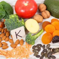 Gesunde Lebensmittel reich an Vitamin K, wichtig für die Schwangerschaft: Spinat, Brokkoli, Avocado, Nüsse, Trockenfrüchte.
