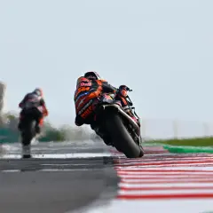 Piloto de MotoGP inclinado en curva, luchando por la pole position en el qualy.