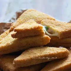 Triangoli dorati di formaggio in carrozza, con il formaggio filante che fuoriesce da uno.