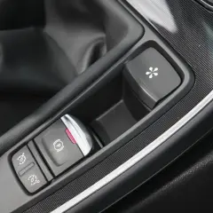 Bouton de frein à main électronique et autres commandes dans une voiture. Le frein à main ne serre plus, prix de la réparation à considérer.