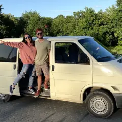 Para młoda pozuje przy swoim t4 camperze, gotowa na przygodę.