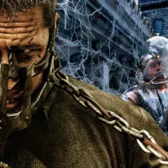 Mroczne klimaty **filmów dystopijnych**: mężczyzna w masce i łańcuchach obok postaci w skafandrze ochronnym na tle zrujnowanego miasta.
