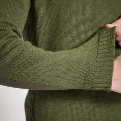 Zielony sweter z łatami na łokciach. Dowiedz się, jak prać wełnę, aby zachować jego jakość.