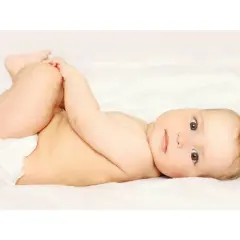 Bambino con pannolino, gambe sollevate, pronto per un cambio per prevenire la candida da pannolino.