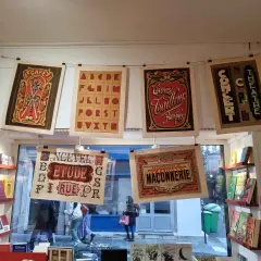 Affiches vintage avec un alphabet décoratif, des publicités de café, de laines et de théâtre.