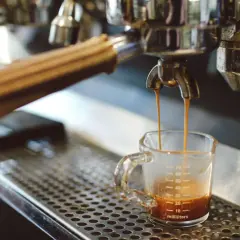 Ekspres do kawy parzy espresso do małej szklanki z miarką.