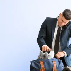 Biznesmen pakuje buty do torby sportowej, zastanawiając się, co ile godzin można korzystać z Multisport Plus.