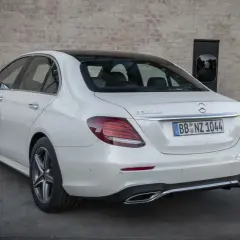 Un Mercedes 300de blanco, con el distintivo "E 300de", está enchufado a un cargador eléctrico.