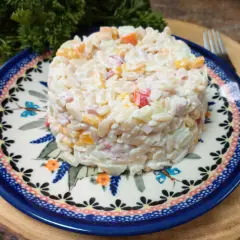 Pyszna sałatka z makaronem orzo, szynką i ogórkiem, podana na ozdobnym talerzu.