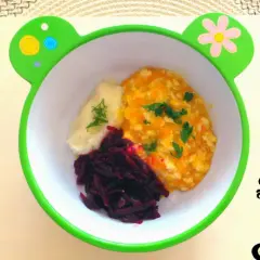 Pyszna potrawka z kurczaka dla niemowlaka z puree ziemniaczanym i buraczkami w miseczce w kształcie żabki.