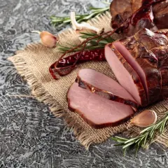 Wędzenie schabu: soczyste plastry na płótnie, ozdobione rozmarynem, czosnkiem i papryczkami chili.