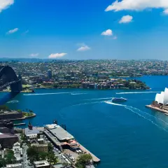 Widok na Zatokę Sydney z Operą i mostem Harbour Bridge. To właśnie Sydney, gdzie błękitna woda lśni w słońcu.