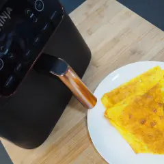Frittata dorata appena sfornata dalla friggitrice ad aria Ninja, pronta per essere gustata.