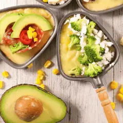 Poêlons de raclette végétarienne avec avocat, brocolis et maïs. Une option gourmande et colorée pour un repas convivial.